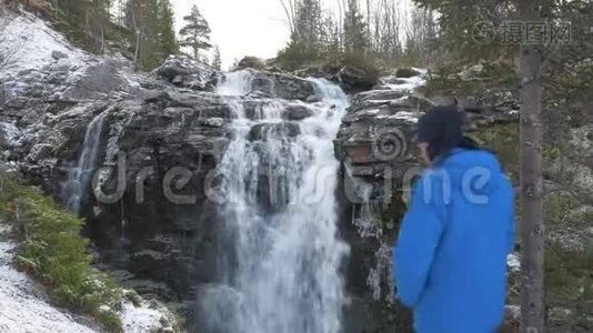 男性旅行者看瀑布。 他在山上休息，欣赏美丽的景色。 人与人的统一视频