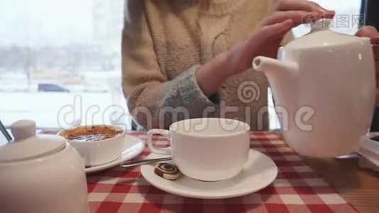 随便女人把有机茶倒进陶瓷杯里。视频