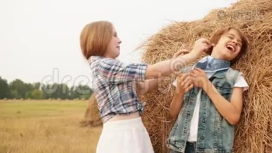 可爱的快乐男孩和女孩在田里玩干草视频