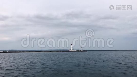 海鸥飞过孤独的灯塔。 多云天气。 乌克兰敖德萨海港。 黑海。视频