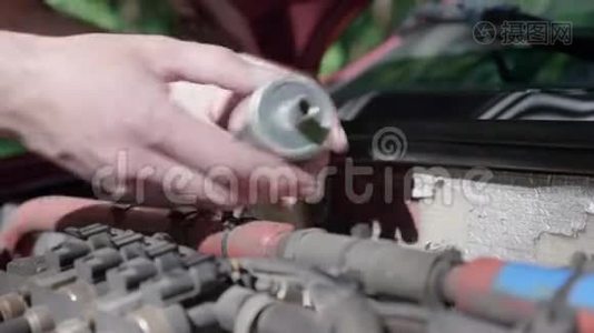 一个独立取代他车里的LPG过滤器的人的手的特写。视频
