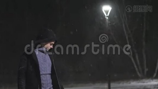 街灯里的那个人。 `在灯的背景下下雪。 在180fps内缓慢运动.. 雪花真美视频