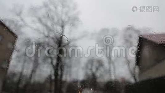 从一辆汽车的内部可以看到下雨的阴郁天气，雨刷积极地清除挡风玻璃上的雨滴视频