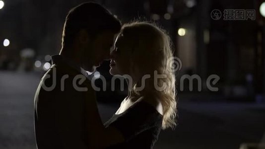 两个相爱的人接吻，浪漫的情侣享受约会，晚上视频