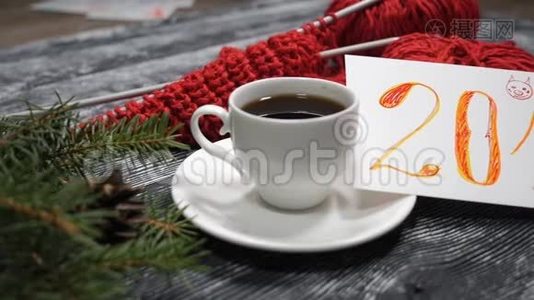 新年2019概念。 一杯咖啡和一张2019年的纸条放在木制背景上，上面还有红色的纱线和红色的纱线视频