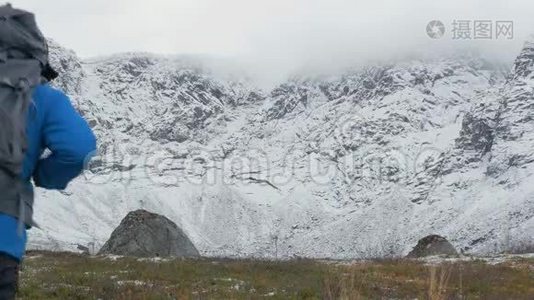 一个带背包的人在山里旅行。 他望着高高的山峰，走得更远。 他的身体健康视频