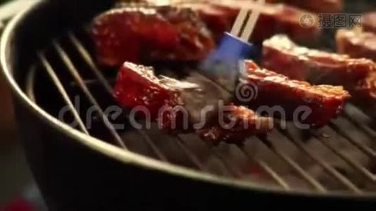 烤架上的猪肉排骨上的卤汁视频