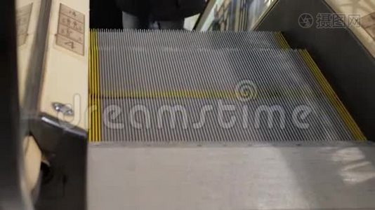 商场里的自动扶梯。 为圣诞节买礼物的人的特写腿。视频