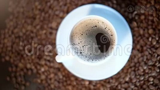 一个白色的咖啡杯站在一堆烤咖啡豆上视频