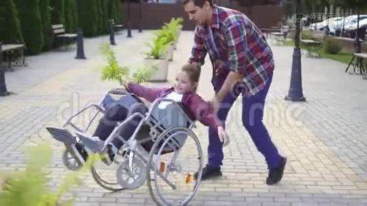 在一个夏天的公园里，一个快乐的少年坐在轮椅上。视频