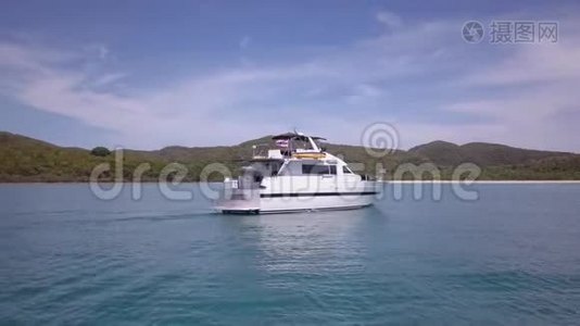 白色游艇侧面拍摄，沿着蓝色的海洋湾平静的海水航行，阳光明媚视频