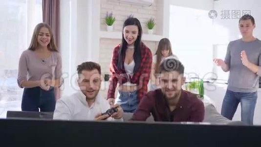 一群快乐的朋友在沙发上玩电脑游戏，在现代公寓里玩得开心视频