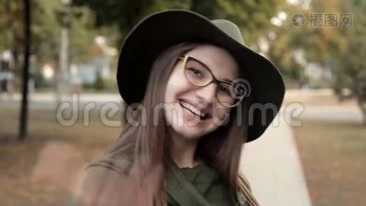 秋天公园里一个快乐的女孩，叫一个朋友。 感情，戴帽子戴眼镜的女孩视频
