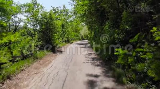 无人机拍摄的山村道路环绕着森林。视频