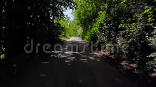 无人机拍摄的山村道路环绕着森林。 4K UHD中弹视频