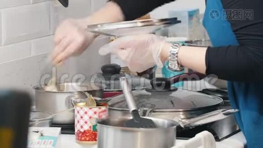 面包店。 一个女人在电炉上做饭。 在平底锅里搅拌一些东西视频
