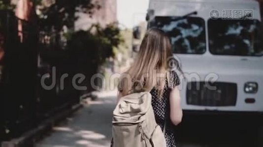 镜头跟随年轻的女游客，背包穿过白色货车附近的街道，享受休闲步行慢动作。视频