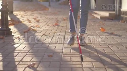 在城里，一个为视障人士准备拐杖的女人正在慢慢地走视频
