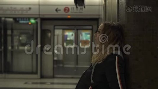 在地铁站站台上等候火车的旅游妇女。 地下旅行的年轻女子。 城市交通。 旅费视频