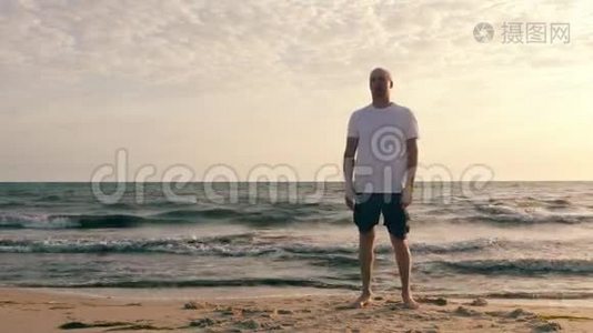海边晨练时做呼吸运动的成年男子视频