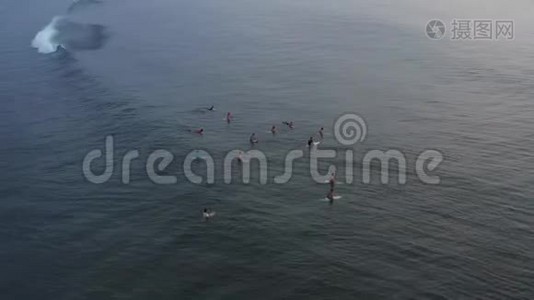 一群冲浪者在晴朗的一天等待海浪。 巨大的印度冲浪者的鸟瞰图视频