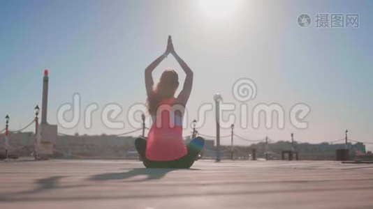 年轻女子在海滩上练习瑜伽。视频