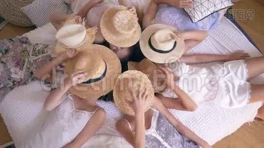 穿着睡衣的快乐女朋友躺在床上，脸上戴着草帽，然后脱下她们，在镜头前微笑视频