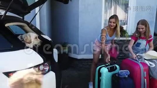 狗坐在车里，女人带着她的孩子装行李。视频