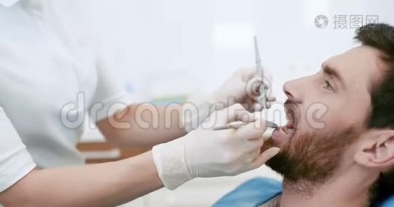 牙科医生口腔检查时张口的年轻男性视频