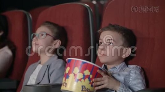 孩子们在电影院看电影。 儿童电影娱乐节目视频