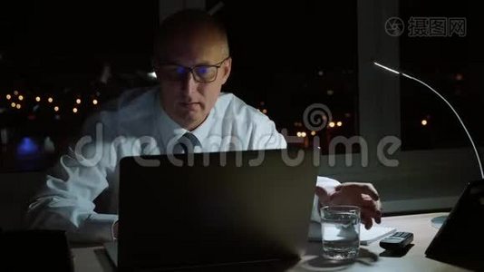 行政商人在黑暗的办公室里用玻璃喝水视频