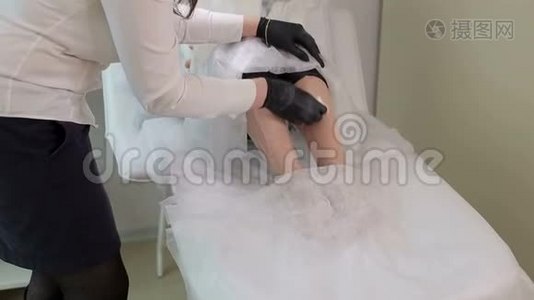 美容师准备女人`腿脱毛。视频