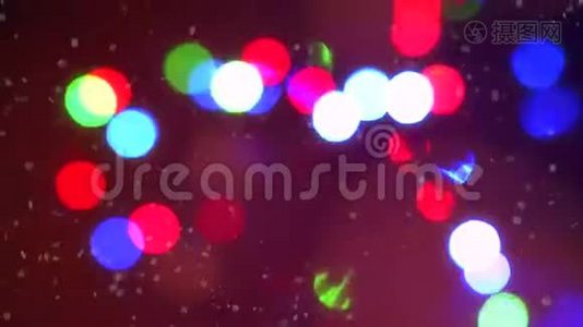 特写彩色闪烁的圣诞花环灯光，背景被飘落的雪花包围视频