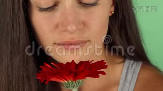 一位美丽的年轻女子在闻一朵花时笑得很开心视频