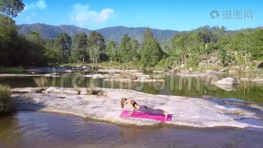 女孩在画河的平地上做瑜伽视频
