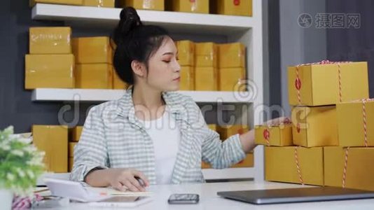 年轻女性企业家在自己的工作中在网上购物时检查包裹箱视频