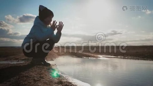 可爱的女孩在日落时在湖边玩纸船。 童梦和旅行理念，生活方式..视频