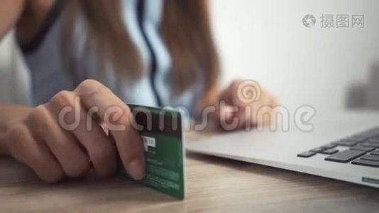 网上购物概念。 女人手拿着信用卡，用笔记本电脑。 女人的手敲桌子上的卡片视频