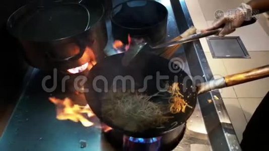 制作亚洲食物的烹饪-在火上的平底锅上新鲜的面条和蔬菜视频