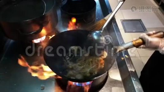 制作亚洲食物的烹饪-在火上的平底锅上新鲜的面条和蔬菜视频