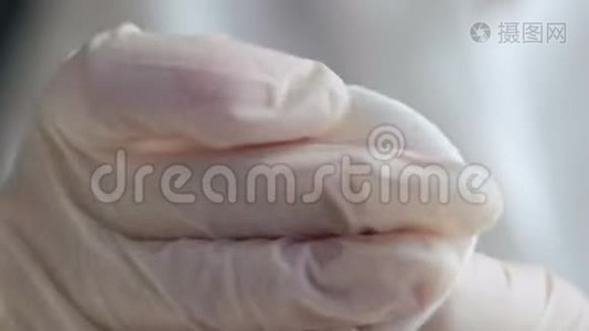 一个戴手套的医生打破了玻璃安瓿的边缘。视频