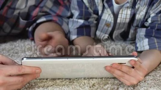 儿子和父亲在家里玩平板电脑游戏，一家人在一起视频
