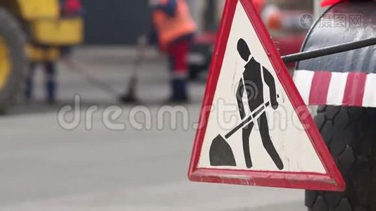 街道上的道路工程标志。 工人们把城市里的新沥青铺在路上。视频