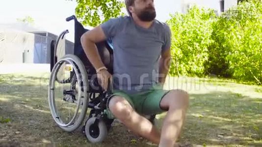 残疾青年试图坐在轮椅上视频