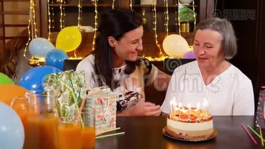 女儿和高年级妈妈在生日蛋糕或母亲节聚会上吹蜡烛视频