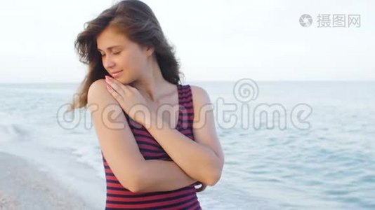 站在海边金色沙滩上的年轻女子的角度。女性的腿在海洋附近行走。赤脚的女孩继续视频