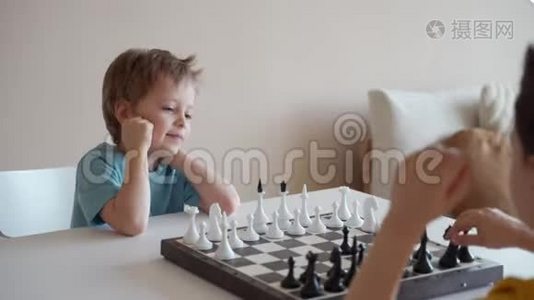 两个男孩在灯光室下棋。 两个兄弟在下棋。视频