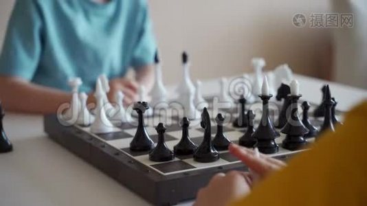 两个男孩在灯光室下棋。 两个兄弟在下棋。视频