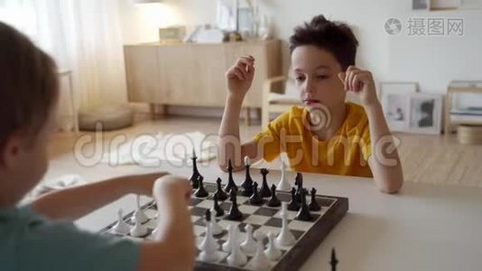 两个男孩在灯光室下棋。 两个兄弟在下棋。视频