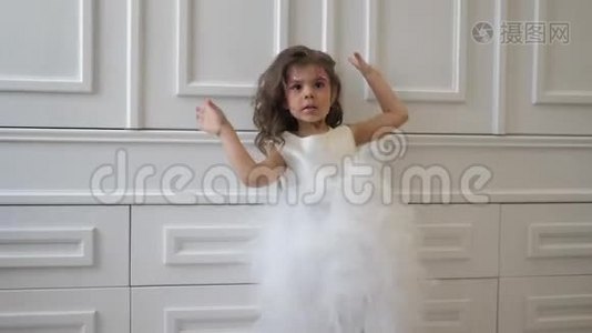 名人小女孩穿着蓬松的连衣裙，脸上有亮片，背景是白色的墙壁视频